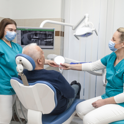 Fogászati vizsgálat közben: a páciens fogait a fogorvos ellenőrzi, miközben egy asszisztens segédkezik.
